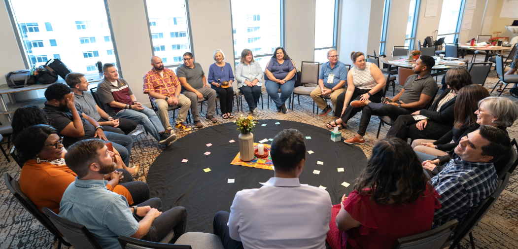 20 people sitting in a circle having discussions