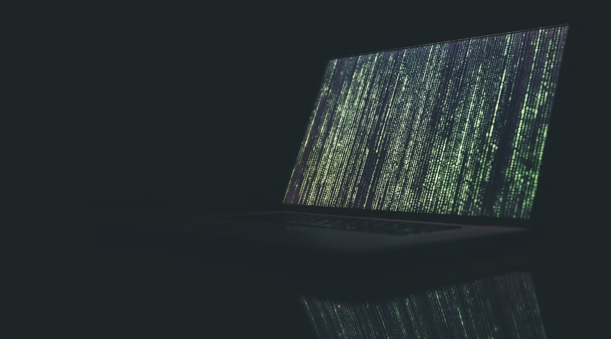 Laptop with green lines of code.
