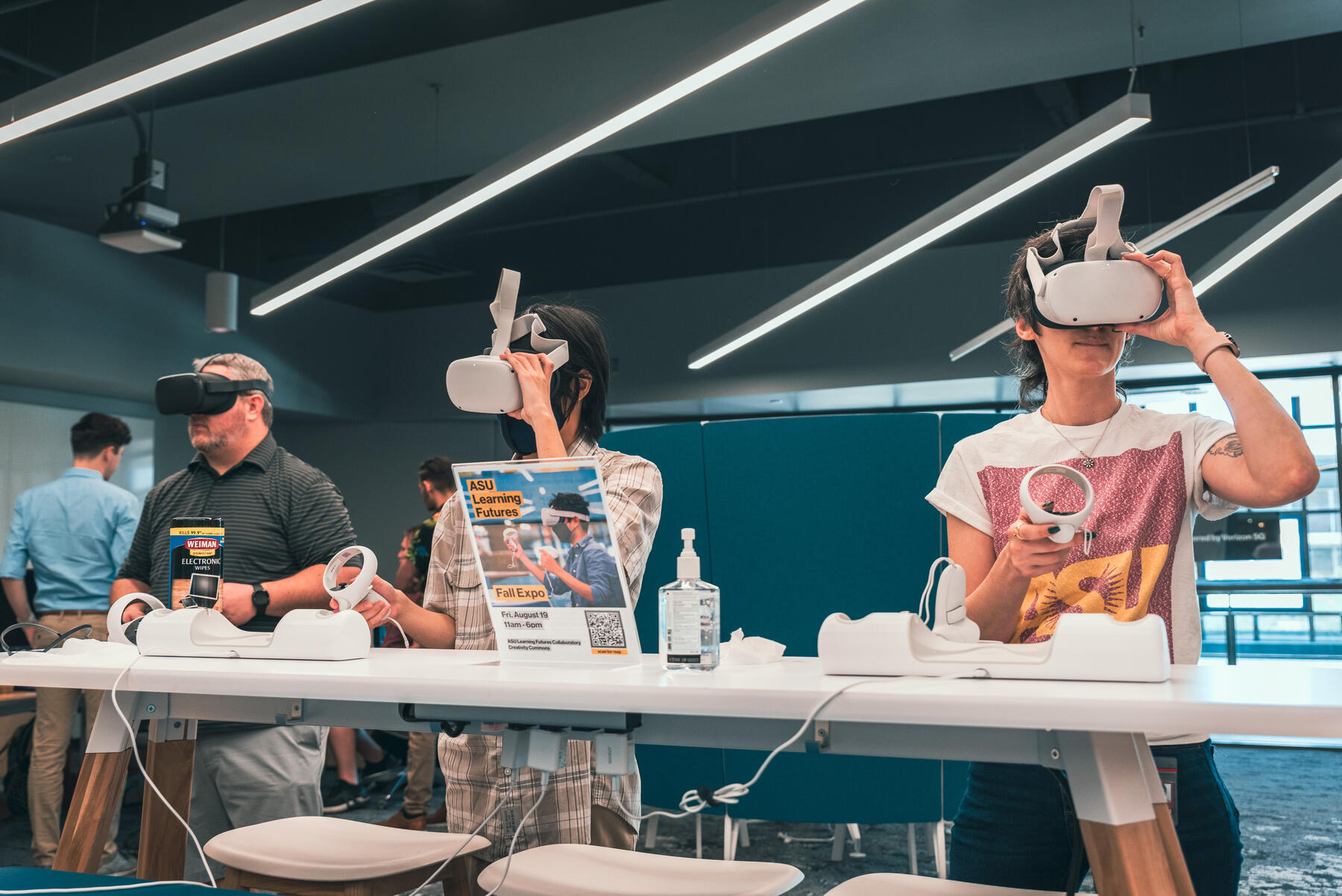 Three people standing with virtual reality headsets on